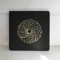 black ceramic tile with white and yellow slip decoration