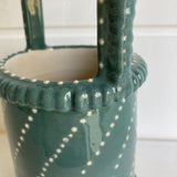 close up Greenish blue vase with white slip dot decoration